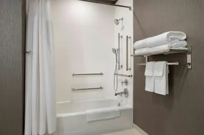 a bathroom with a tub and a shower with towels at SpringHill Suites Danbury in Danbury