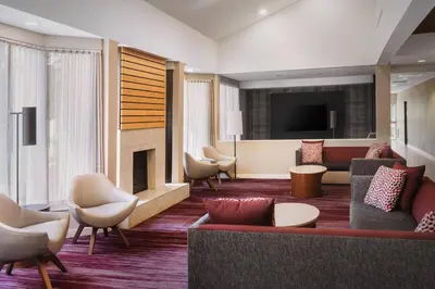 a lobby with a couch and chairs and a television at Courtyard by Marriott Fishkill in Fishkill