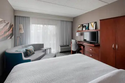 a hotel room with a bed and a television at Courtyard by Marriott Fishkill in Fishkill