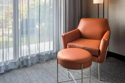 an orange chair in a room with a window at Courtyard by Marriott Tarrytown Westchester County in Tarrytown