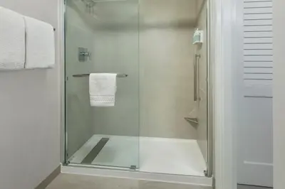 a shower with a glass door in a bathroom at Courtyard by Marriott Tarrytown Westchester County in Tarrytown