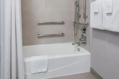 a bathroom with a white tub and a shower at Courtyard by Marriott Tarrytown Westchester County in Tarrytown