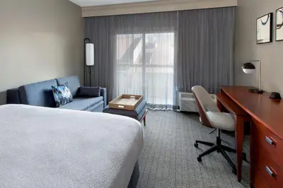 a hotel room with a bed and a desk and a chair at Courtyard by Marriott Tarrytown Westchester County in Tarrytown