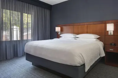 a bedroom with a large bed and a large window at Courtyard by Marriott Norwalk in Norwalk