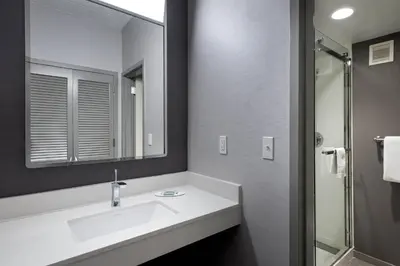 a white bathroom with a sink and a mirror at Courtyard by Marriott Norwalk in Norwalk
