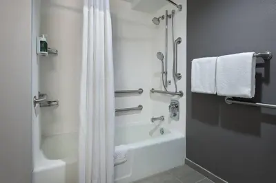 a bathroom with a shower and a white shower curtain at Courtyard by Marriott Norwalk in Norwalk