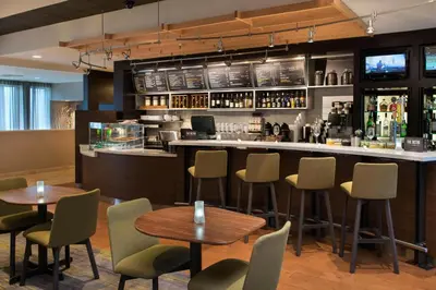a bar in a restaurant with tables and chairs at Courtyard by Marriott Norwalk in Norwalk