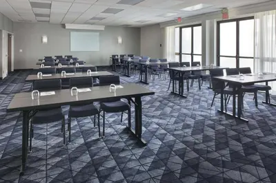 a classroom with tables and chairs in a room at Courtyard by Marriott Norwalk in Norwalk