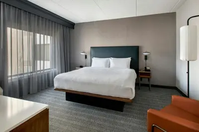 a hotel room with a bed and a large window at Courtyard by Marriott Rye in Rye