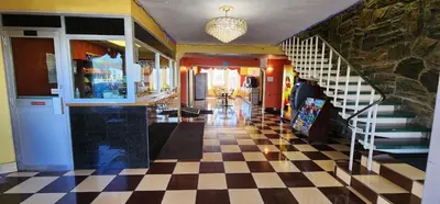 a lobby with a checkered floor and a staircase at Town House Inn and Suites in Elmwood Park