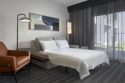 a hotel room with a bed and a chair at Courtyard by Marriott Poughkeepsie in Poughkeepsie