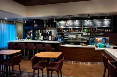 a bar in a restaurant with tables and chairs at Courtyard by Marriott Poughkeepsie in Poughkeepsie