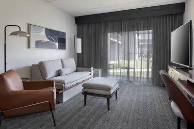 a living room with a couch and a tv at Courtyard by Marriott Poughkeepsie in Poughkeepsie