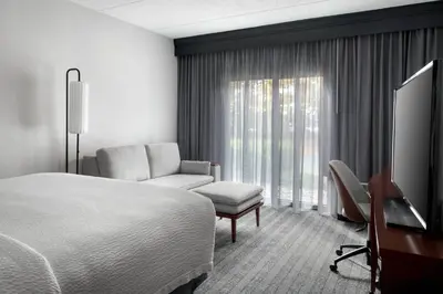 a hotel room with a bed and a chair and a desk at Courtyard by Marriott Poughkeepsie in Poughkeepsie