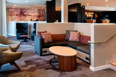 a lobby with a couch and a table and chairs at Courtyard by Marriott Poughkeepsie in Poughkeepsie