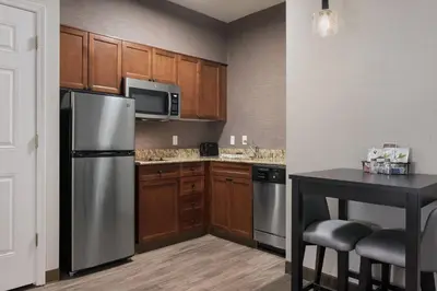 a kitchen with wooden cabinets and a stainless steel refrigerator at Residence Inn Poughkeepsie in Poughkeepsie