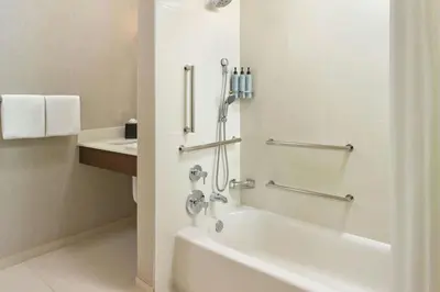 a white bathroom with a tub and a sink at Residence Inn Poughkeepsie in Poughkeepsie