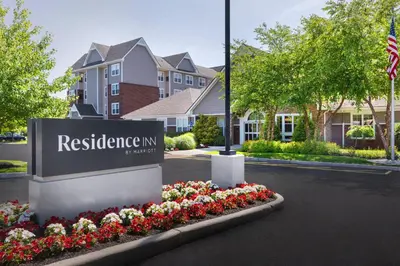 a sign for a residence inn with flowers in a yard at Residence Inn Poughkeepsie in Poughkeepsie