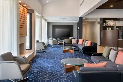 a living room with couches and a flat screen tv at Courtyard by Marriott New Haven Wallingford in Wallingford