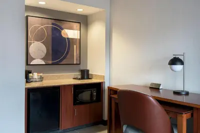 a hotel room with a desk and a microwave at Courtyard by Marriott New Haven Wallingford in Wallingford