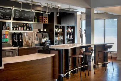a bar with bar stools and bottles of alcohol at Courtyard by Marriott New Haven Wallingford in Wallingford