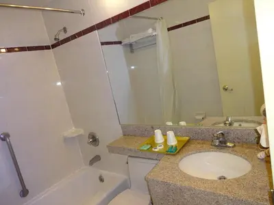 a bathroom with a sink and a toilet and a tub at Flushing Hotel in Queens