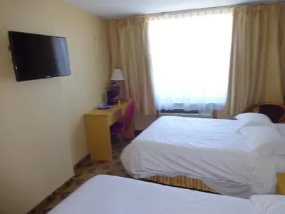 a hotel room with two beds and a flat screen tv at Flushing Hotel in Queens