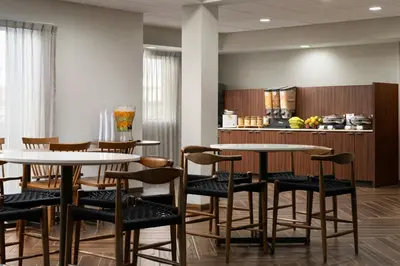 a room with two tables and chairs and a kitchen at Fairfield Inn & Suites by Marriott Newark Liberty International Airport in Newark