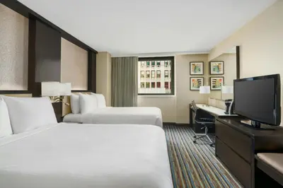 a hotel room with two beds and a television at Courtyard New York Manhattan/Times Square in New York