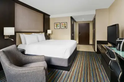 a hotel room with a large bed and a chair at Courtyard New York Manhattan/Times Square in New York