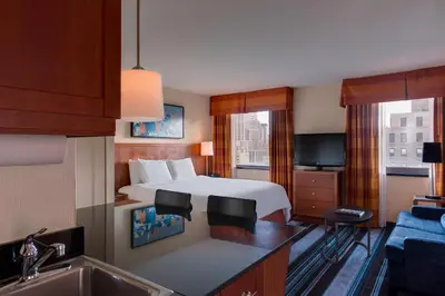 a hotel room with a bed and a kitchen with a sink at Residence Inn by Marriott New York Manhattan/Times Square in New York