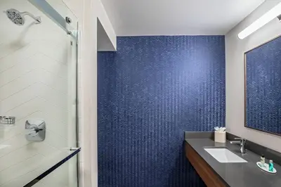 a bathroom with a sink and a blue wall at Fairfield Inn & Suites by Marriott Saratoga Malta in Malta