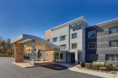 a hotel with a large building with couches in a parking lot at Fairfield Inn & Suites by Marriott Albany Airport in Albany