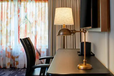 a desk with a lamp and a table with chairs at Fairfield Inn & Suites by Marriott Albany Airport in Albany