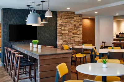 a bar in a restaurant with tables and chairs at Fairfield Inn & Suites by Marriott Albany Airport in Albany