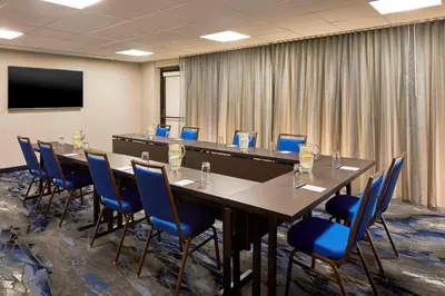 a conference room with a long table and blue chairs at Fairfield Inn & Suites by Marriott Albany Airport in Albany