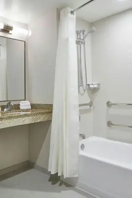 a bathroom with a tub and a shower with a shower curtain at Fairfield Inn & Suites by Marriott Albany Airport in Albany