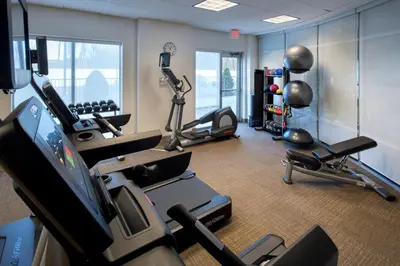 a gym with several cardio machines and a television at SpringHill Suites by Marriott Albany Latham-Colonie in Albany