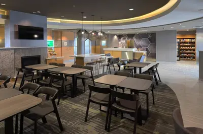a restaurant with tables and chairs and a fireplace at SpringHill Suites by Marriott Albany Latham-Colonie in Albany