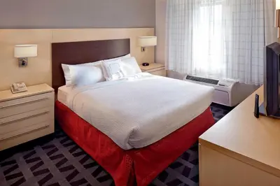 a hotel room with a large bed and a television at TownePlace Suites by Marriott Albany Downtown/Medical Center in Albany