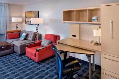 a hotel room with a desk and a couch and a table at TownePlace Suites by Marriott Albany Downtown/Medical Center in Albany