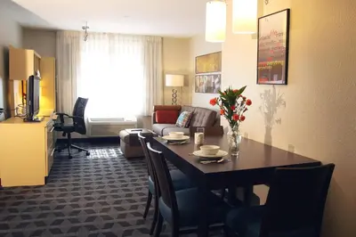 a room with a dining table and a living room at TownePlace Suites by Marriott Albany Downtown/Medical Center in Albany