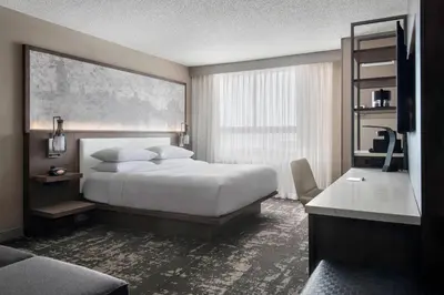 a bedroom with a large white bed and a desk at Marriott Albany in Albany