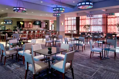 a restaurant with tables and chairs and a bar at Marriott Albany in Albany