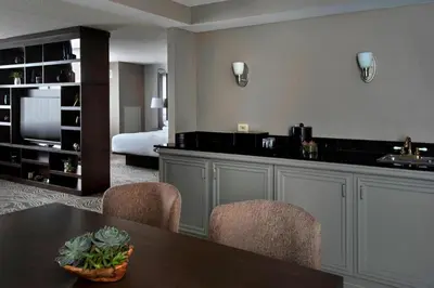 a living room with a table and chairs and a bedroom at Marriott Albany in Albany