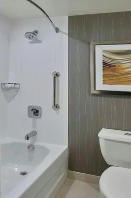a bathroom with a white sink and a toilet at Courtyard by Marriott Albany Thruway in Albany