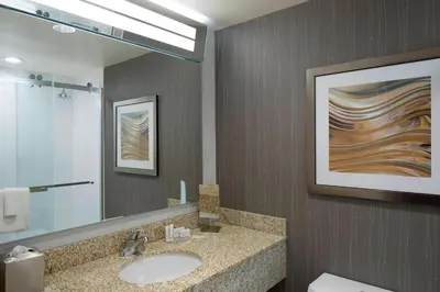 a bathroom with a sink and a mirror at Courtyard by Marriott Albany Thruway in Albany
