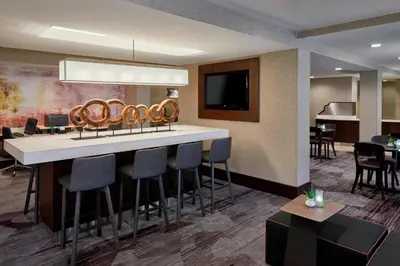 a bar in a hotel room with stools at Courtyard by Marriott Albany Thruway in Albany