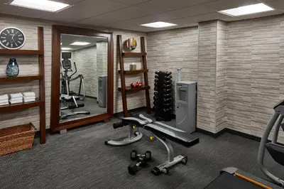 a gym with tread machines and a mirror at Courtyard by Marriott Albany Thruway in Albany