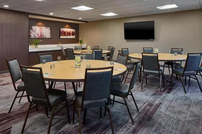 a conference room with tables and chairs and a flat screen tv at Courtyard by Marriott Albany Thruway in Albany